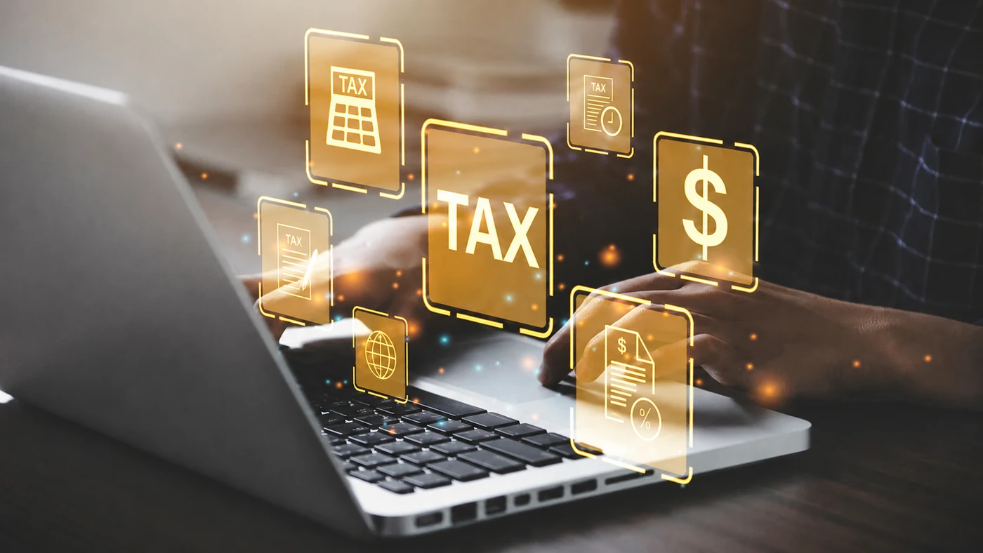 Laptop with glowing gold tax icons — TAX, dollar, calculator, and document symbols